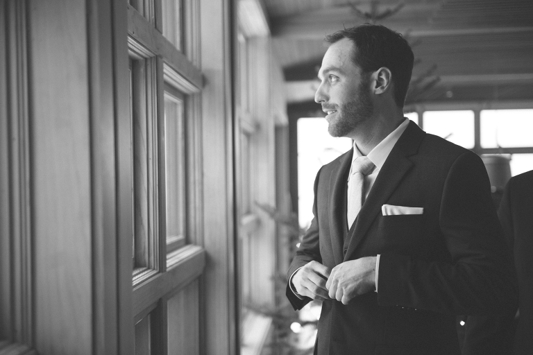 groom getting ready in front of a window
