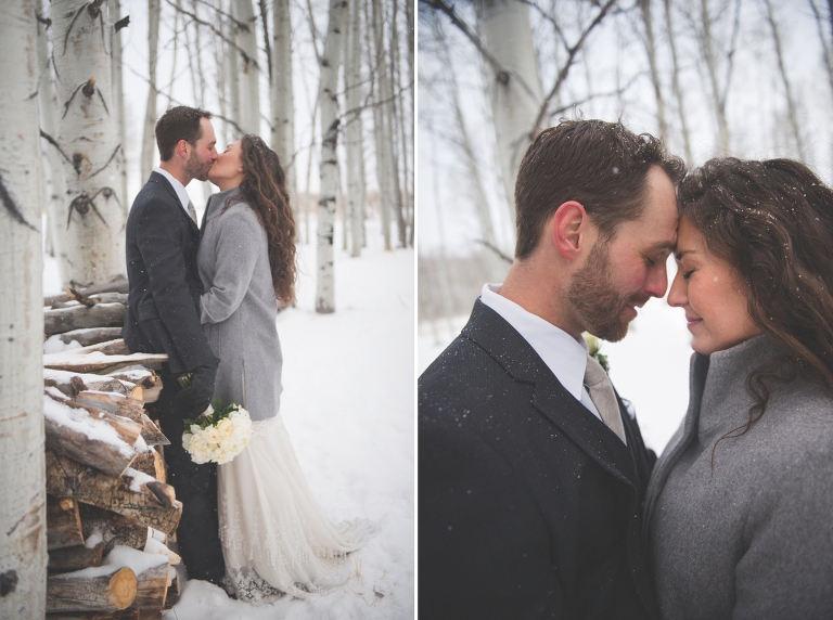 couple kissing by snow covered wood