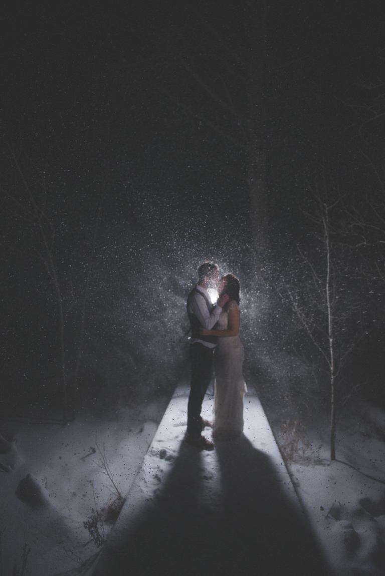 bride and groom standing in the snow at night in Silverthorne, Colorado
